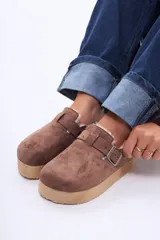 Sueco de plataforma color negro, con exterior de gamuza, interior forrado en piel sintética y detalle de corcho en el talón. Cuenta con una tira ajustable con broche metálico en el empeine.