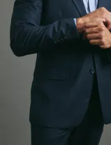 Ambo de vestir para hombre compuesto por saco de dos botones y pantalón de corte recto, en color azul oscuro.