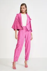 Pantalón de vestir rosado con corte holgado, tiro alto, bolsillos laterales con cierre y cierres en los tobillos.