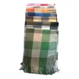 Bufanda rectangular de tejido afelpado con diseño de cuadros en tonos rosado, gris y beige. Presenta terminaciones con flecos en los extremos.