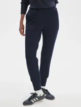 Pantalón tipo jogger de color azul marino, corte entallado (slim) con puños ajustados en los tobillos y tiro medio. Presenta cintura elástica con cordón de ajuste y bolsillos laterales.