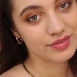 Par de aros dorados con forma de argolla abierta y diseño doble.