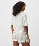Pijama corto de dos piezas confeccionado en viscolycra con estampado de cuadros. Compuesto por una camisa de mangas cortas con cuello de solapa y cierre frontal de botones, y un short con cintura elastizada.