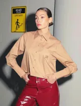 Camisa color camel de poplin de algodón, manga larga y largo a la cintura. Tiene un bolsillo bordado con el isologo de Renée a tono.