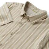 Camisa de manga corta de tejido técnico perforado con fibras Tactel transpirables y stretch, ideal para climas cálidos. Presenta un diseño a rayas verticales en tonos beige y blanco, con cuello camisero y cierre frontal de botones.