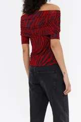 Camiseta de animal print de cebra, con escote recto con vuelta, hombros descubiertos y mangas 3/4 ajustadas.