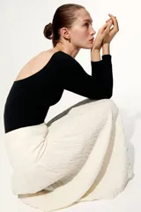 Pollera evasé midi de punto texturizado en color blanco, con elástico revestido en la cintura y costura fruncida con ribete bajo la cadera.