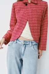 Blazer cruzado de tweed rojo con patrón texturizado en tonos blanco y negro, cuello con solapa, manga larga y cierre frontal con un botón.