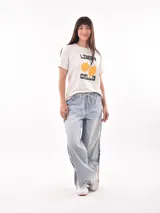 Remera color beige con estampa de texto 'Seaside Florida USA' y dibujo de coral en color lila.