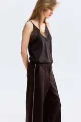 Pantalón sastrero de tejido efecto neopreno color marrón oscuro, de corte recto con raya central pespuntada y franja lateral en color rosado contrastante. Cuenta con bolsillos al bies y cierre frontal con botón oculto y corchete.