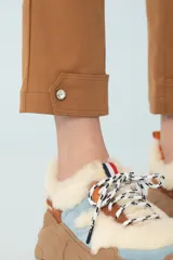 Pantalón cargo color camel, de corte recto, con bolsillos laterales con solapa y botón, y botones decorativos en el ruedo.