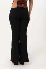 Pantalón negro de tiro alto con cierre frontal de cremallera y botón, bolsillos delanteros y traseros, y corte evasé en el bajo.