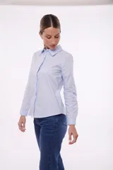 Camisa blanca de manga larga con cuello clásico y cierre frontal con botones.