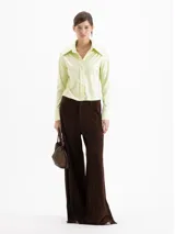 Camisa de jacquard con diseño de flores sutiles, color blanco, con cuello amplio de puntas marcadas, mangas largas con puños y cierre frontal con botones.