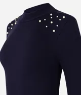 Blusa azul marino de mangas largas, confeccionada en rib con viscosa, cuello alto y perlas artificiales aplicadas en los hombros.