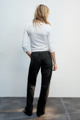 Jeans de tiro bajo y cinco bolsillos, de pierna ancha y larga. Cuenta con cierre frontal con cremallera y botón metálico.