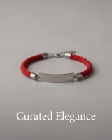 Pulsera de cordón rojo con chapa de identidad en acero y terminales metálicas.