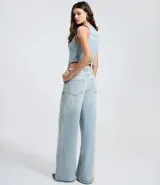 Pantalón wide leg de tiro medio confeccionado en denim de algodón. Presenta un diseño de cintura cruzada con cierre tradicional, trabillas para cinturón y bolsillos funcionales.