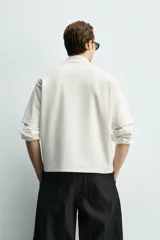 Camiseta de corte relajado confeccionada en tejido interlock de algodón con elasticidad, cuello redondo y manga corta.
