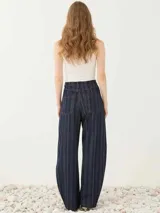 Pantalón de cinco bolsillos de tiro alto y pierna amplia con diseño de rayas finas verticales, confeccionado en tejido denim con cierre frontal de botón y presillas para cinturón.