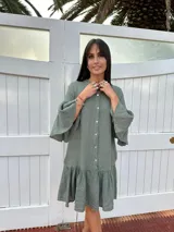 Vestido corto color verde militar, con cuello mao, botones frontales, mangas cortas acampanadas y volados en el ruedo. Confeccionado en lino. Fabricado en Italia.