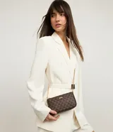 Bolso bandolera rectangular de poliuretano color marrón con estampado de triángulos y correa de cadena dorada.