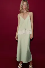 Vestido midi de satén color verde menta con escote en V, tirantes finos y detalle de encaje blanco en el pecho.
