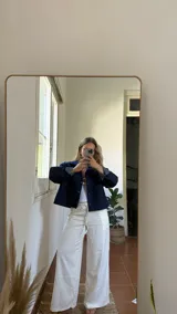 Campera de denim azul oscuro con botones a presión y dos bolsillos frontales.