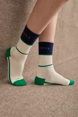 Medias de caña media con diseño tricolor en blanco, verde y azul marino. Presentan el logo de la marca bordado en la parte superior y puntera y talón reforzados en color verde.