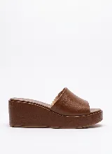 Sandalia de plataforma tipo zueco color marrón, confeccionada en cuero vacuno, con capellada ancha y taco chino forrado.