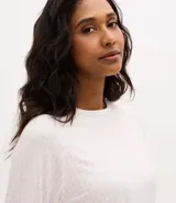 Blusa de pijama de manga larga con cuello redondo, confeccionada en tejido rib con estampado de cuadros en tonos claros.