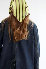 Pañuelo triangular de tejido de punto con diseño de rayas horizontales en tonos azul y celeste. Presenta bordes con acabado deshilachado.