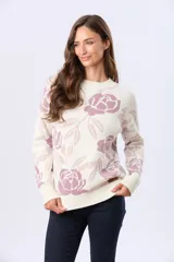 Buzo tejido en jacquard con diseño floral en tonos rosados sobre base color crema. Presenta cuello redondo, mangas largas y puños con terminación en rib.