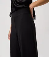 Pantalón de sastrería modelo pantalona, de corte amplio y tiro alto, con cintura lisa y pliegues frontales. Confeccionado en tejido de poliéster con elastano.