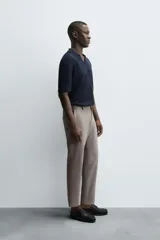 Pantalón chino de corte slim fit, confeccionado en tejido elástico. Presenta bolsillos frontales, bolsillos traseros de vivo con botón y cierre frontal con cremallera y botón.