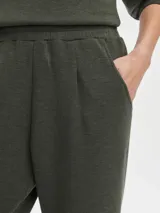 Pantalón de jogging color verde oliva, confeccionado en tejido DoubleSoft®, con corte ajustado, pinzas delanteras y traseras, y bajo enrollado.