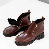 Bota de cuero vacuno color marrón, con interior forrado en corderito natural. Tiene suela de goma artesanal, punta cuadrada, cierre YKK en ambos lados y caña de 11cm.