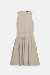 Vestido midi sin mangas de cuello redondo, con falda amplia con frunces y bolsillos laterales ocultos. Presenta cierre en la espalda con abertura y botón.