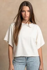 Remera oversize de algodón blanco crudo, con cuello redondo y mangas cortas anchas de corte relajado.