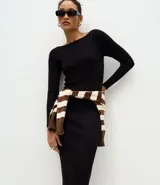 Vestido midi de punto acanalado en color marrón chocolate, con cuello barco y mangas largas. Presenta un corte ajustado al cuerpo y una textura de malla fina.