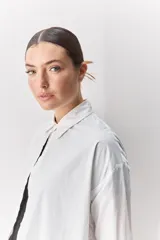 Camisa de algodón de calce relajado con cuello clásico, mangas largas con puños abotonados y cierre frontal con botones.