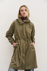 Campera impermeable negra a la rodilla de corte amplio, con cierre frontal, capucha, bolsillos y elástico en los puños. Cuenta con cordones de diseño personalizado en la cintura y la capucha, y detalles en símil cuero en bolsillos y cierre delantero.