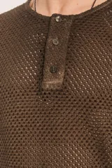 Camiseta de punto con estructura abierta tipo crochet, de corte relajado, cuello panadero con cierre frontal de botones y manga larga.