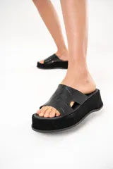 Sandalias negras con tira ancha de cuero con textura de cocodrilo y plataforma forrada en descarne.