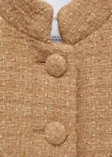 Chaqueta de corte recto confeccionada en tejido tweed con mezcla de lana. Presenta cuello de tira, cierre frontal con botones, manga larga y cuatro bolsillos delanteros con solapa y botón. Incluye forro interior.