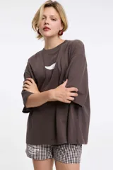 Remera de corte boxy color gris oscuro, con cuello redondo y mangas cortas. Presenta un diseño estampado localizado en la parte superior del pecho.