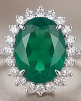 Anillo de plata con piedra central tallada en corte ovalado de color verde esmeralda, rodeada por un pavé de pequeñas circonias brillantes.