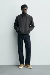 Zapatillas de cordones color beige, fabricadas en piel con acabado serraje. Presentan detalles de pespuntes en la parte superior y suela plana a contraste color crema.