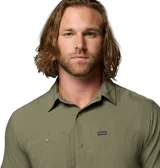 Camisa de manga corta Columbia, color verde oliva, con cuello clásico, cierre frontal de botones y dos bolsillos frontales en el pecho. Presenta un diseño técnico con ventilación en la espalda, ideal para actividades al aire libre.