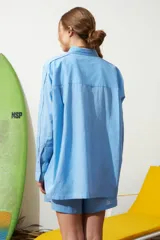 Camisa celeste de poplin con ribete decorativo en los bordes.